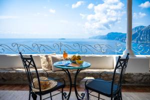 a table and chairs with a view of the ocean at Villa Santa Chiara Positano Suites in Positano