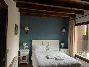a bedroom with a bed with two towels on it at Apartamentos La Senda in San Juan de Parres