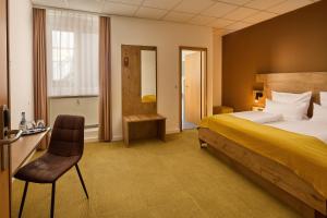 a hotel room with a bed and a chair at Hotel Am Markt in Karlsruhe