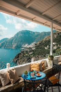 a table on a balcony with a view of the ocean at Villa Santa Chiara Positano Suites in Positano