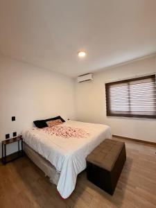 a bedroom with a large bed and a ottoman at Manzanillo Homestay Room in Manzanillo