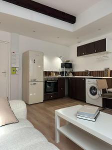 a living room with a white couch and a kitchen at Le Petit Palais, en hyper centre de Valence in Valence