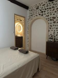 a bedroom with a bed and a stone wall at Le Petit Palais, en hyper centre de Valence in Valence +7 photos