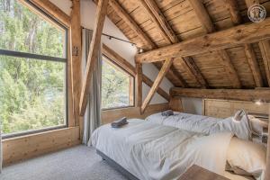 two beds in a room with a large window at Chalet de l'epigny in Bellecombe