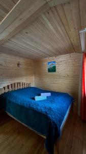 a bedroom with a bed in a wooden cabin at LEMI Mountain Cottages - Ushguli in Ushguli