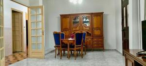 a dining room with a table and blue chairs at Layna in El Mouradia
