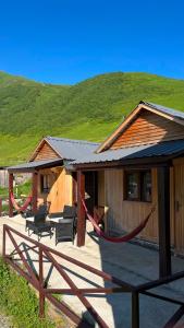 a house with a hammock in front of it at LEMI Mountain Cottages - Ushguli in Ushguli