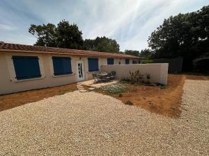 a house with blue windows and a gravel yard at BlakRiverHouse - Sèvre Niortaise in Niort