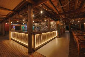a restaurant with a bar with lights on the wall at Casa Manoa Pousada in Maragogi