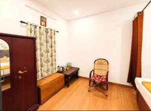 a bedroom with a couch and a desk and a chair at CloudHill Retreat in Ariankāvu +28 photos