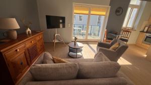 a living room with a couch and a tv at Apartments in Warnemuende in Warnemünde +51 photos
