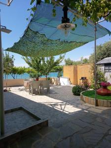 a patio with a table and a blue umbrella at Antonia's house on the beach in Skala Sotiros