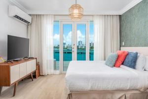 a bedroom with a large bed and a television at Premier Ocean Lagoon Studio · Condado with Pool in San Juan
