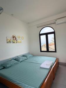 a bedroom with a large bed with a window at Nhan's Home in Hưng Nhơn (2) +20 photos