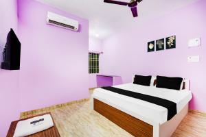 a bedroom with a bed and a flat screen tv at Hotel O Royal Midlaans in Kālapettai