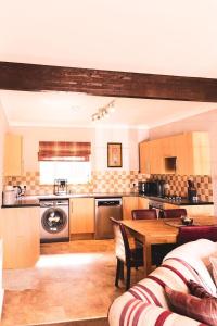 a kitchen with a table and a dining room at Ardbrae Cottage in Daviot