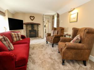 a living room with couches and a fireplace at Little Wickers in Wareham