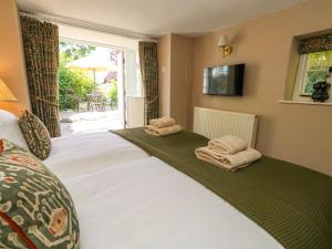 a bedroom with a large bed with towels on it at Little Wickers in Wareham