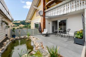 a patio with a pond in the middle of a house at Ferienwohnung Waldrose in Oberharmersbach
