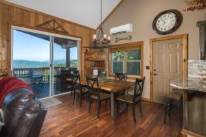 a dining room with a table and chairs and a clock at Grey Fox in Banner Elk