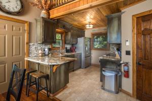 a kitchen with wooden cabinets and a large clock on the wall at Grey Fox in Banner Elk +34 photos