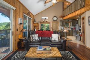 a living room with a leather couch and a table at Grey Fox in Banner Elk