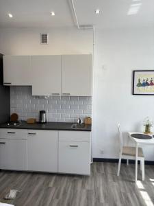 a kitchen with white cabinets and a table and a chair at Willa Pod Platanem in Bytów +45 photos