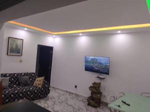 a living room with a couch and a tv on the wall at Immobilier Du siecle in Abidjan