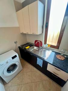 a small kitchen with a sink and a washing machine at Villa Kalaj in Baks-Rrjoll