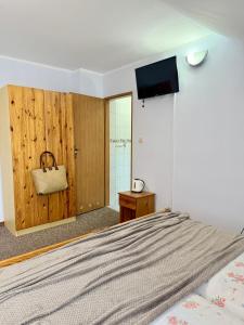 a bedroom with a bed with a television on the wall at Pokoje Alina, 500m do morza ze śniadaniem in Grzybowo