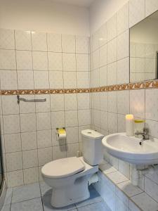 a bathroom with a toilet and a sink at Pokoje Alina, 500m do morza ze śniadaniem in Grzybowo +55 photos