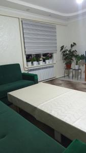 a bedroom with a bed and a window with plants at Bilalguesthouse in Dzhangyaryk