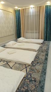 a row of beds in a room with a rug at Bilalguesthouse in Dzhangyaryk