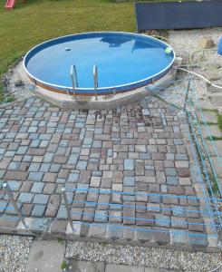 a swimming pool sitting on top of a brick yard at Penzion Chřiby in Staré Hutě