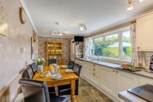 a kitchen with a wooden table and chairs in a kitchen at 3 Bed in Brecon oc-bn363 in Brecon