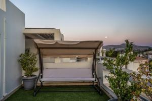 a chair on the balcony of a apartment at Βίλα Λαγονήσι in Kalívia Thorikoú +53 photos