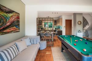 a living room with a couch and a pool table at Βίλα Λαγονήσι in Kalívia Thorikoú