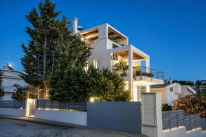 a white house with trees on the side of it at Βίλα Λαγονήσι in Kalívia Thorikoú