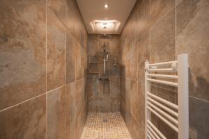 a bathroom with a shower with brown tiles at Chambres D'hôtes Histoire D'anges in Singles +60 photos