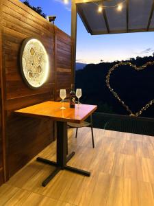 a room with a table and two glasses of wine at cabaña emanuel in Sopetrán