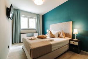 a bedroom with a bed with a blue wall at Große Strandmuschel - 5-Sterne Ferienwohnung zwischen Ostsee und Bodden in Wustrow