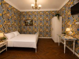 a bedroom with a bed and floral wallpaper at Belli Siciliani Bed&Breakfast in Bucharest