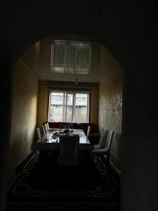 a dining room with a table and chairs and a window at Jumgal Nomad Nest in Kyzart