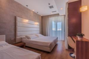 a hotel room with two beds and a desk at AmbientHotels Panoramic in Rimini +74 photos