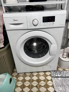 a white washing machine with a black door at Jumgal Nomad Nest in Kyzart