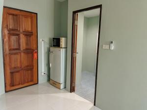 a room with a door and a refrigerator in a room at Orient Hotel in Jomtien Beach