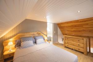 a bedroom with a large bed and a wooden wall at Chambres D'hôtes Histoire D'anges in Singles