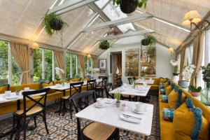 a restaurant with tables and chairs and windows at Victoria Square & The Orangery in Stirling