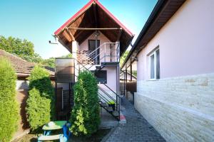 a house with a spiral staircase next to a building at CASA DODO in Călimăneşti