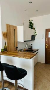 a kitchen with a counter and a black chair at Apartament Piaskowy Kołłątaja in Tomaszów Mazowiecki